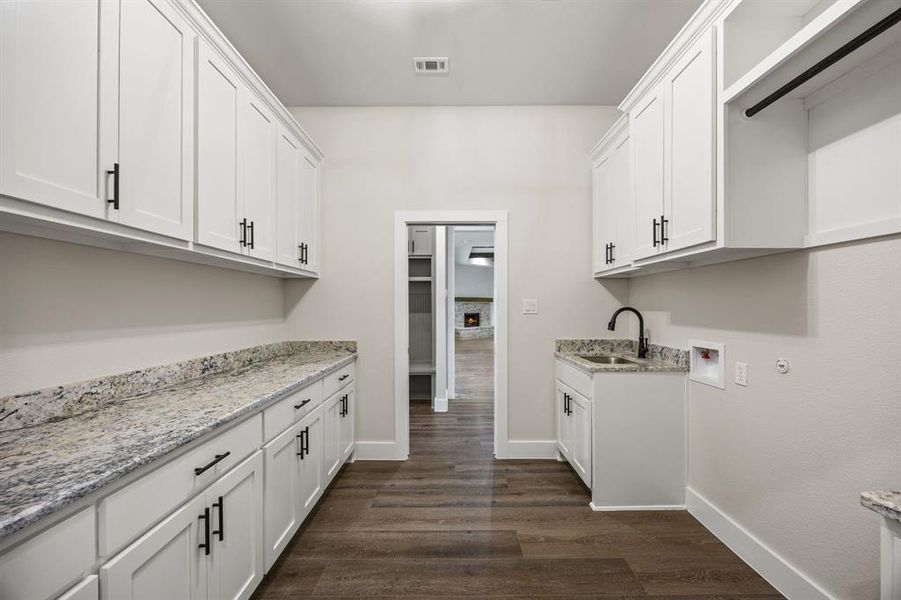Laundry room featuring washer hookup, dark wood-style floors, and cabinet space Laundry room featuring washer hookup, dark wood-style floors, and cabinet space