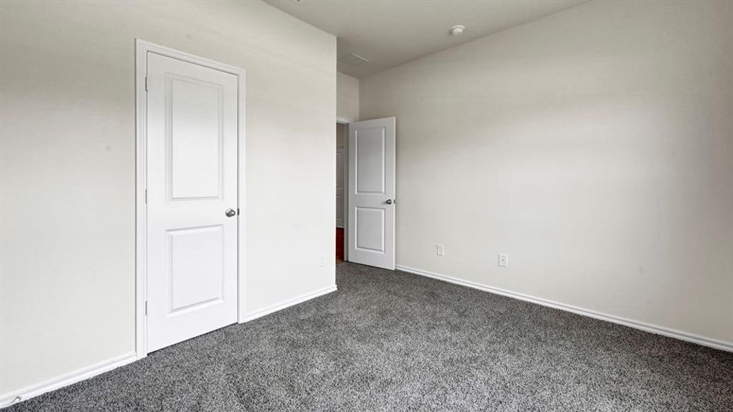 Neutral tone walls with gray low-pile carpeting, baseboard molding, and white interior doors