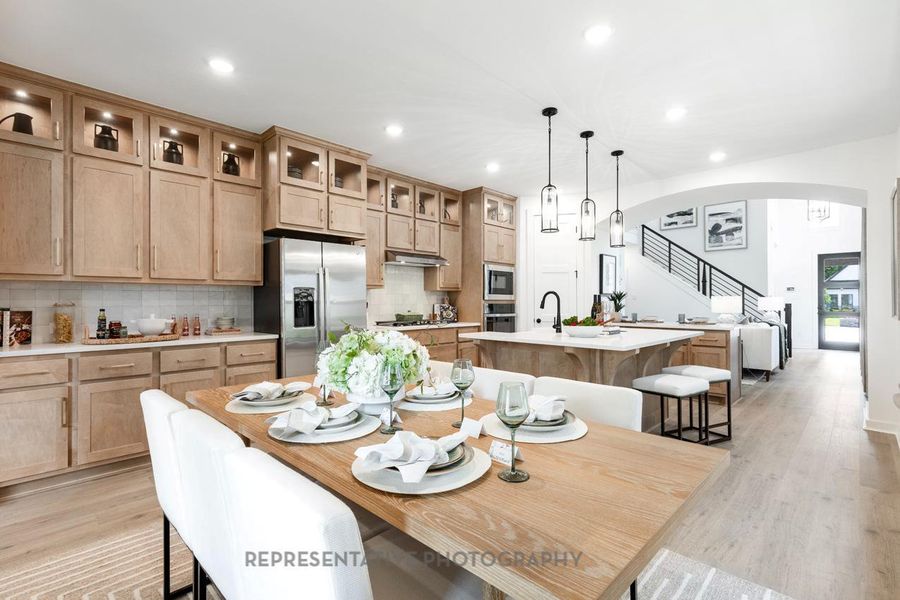 Dining area with arched walkways, light wood-type flooring, recessed lighting, and stairway Dining area with arched walkways, light wood-type flooring, recessed lighting, and stairway