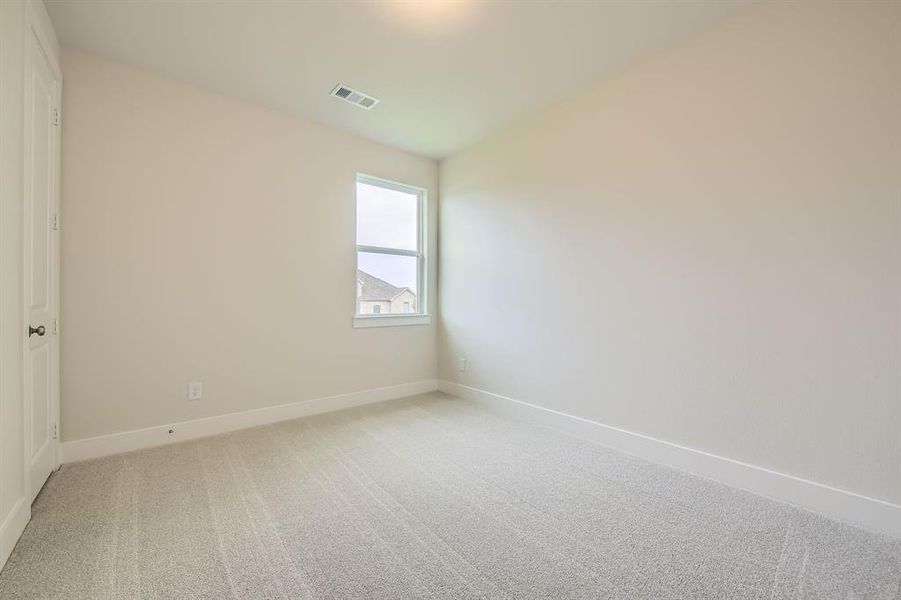 Empty room with baseboards and light colored carpet