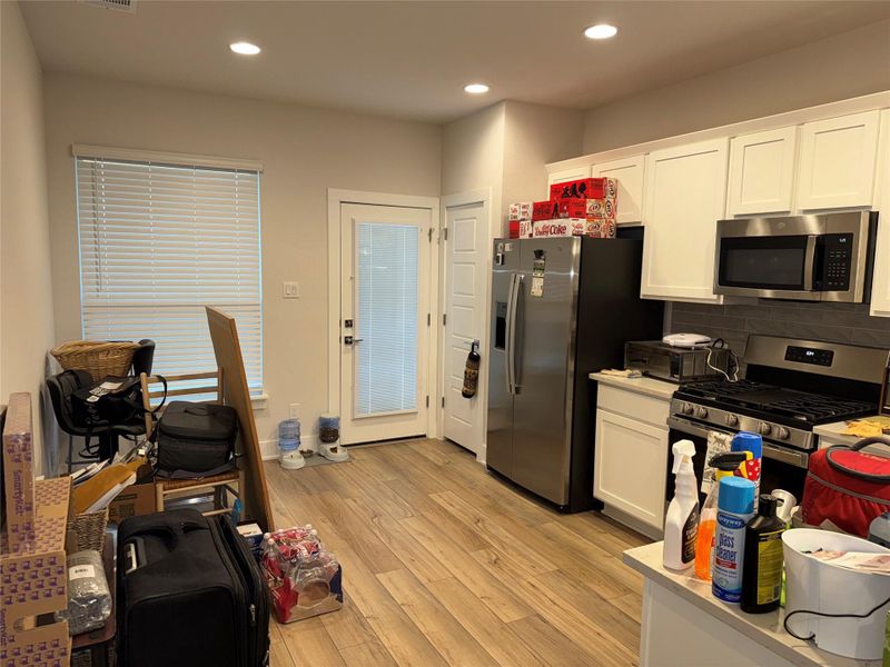 Kitchen featuring white cabinets, stainless steel stove, light countertops, recessed lighting, and decorative backsplash