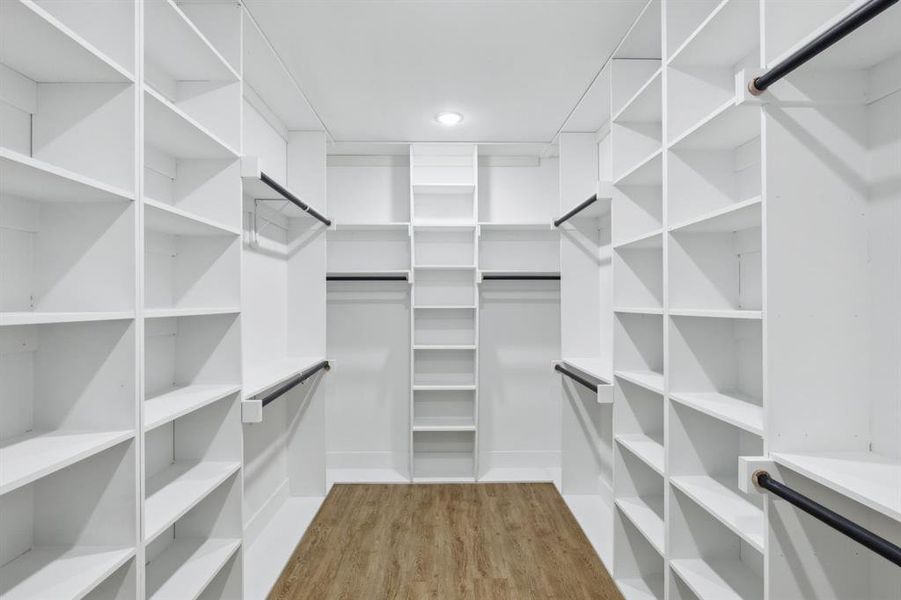 Walk in closet with wood-type flooring