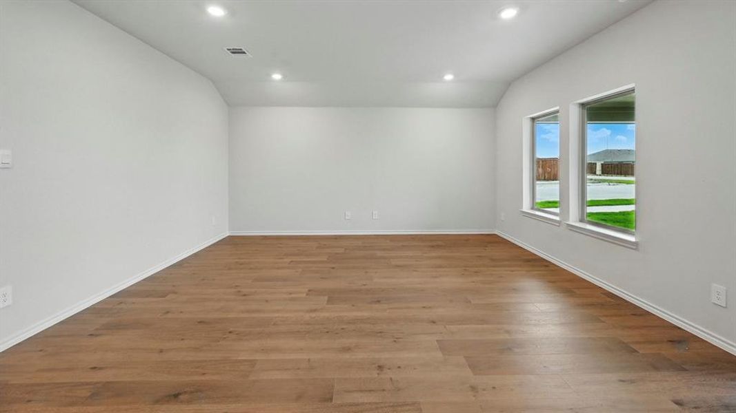 Spare room with vaulted ceiling, recessed lighting, and dark wood-style flooring