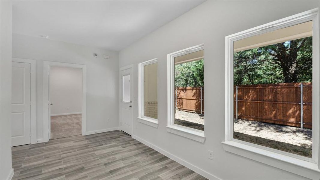 Empty room with light hardwood / wood-style flooring and plenty of natural light