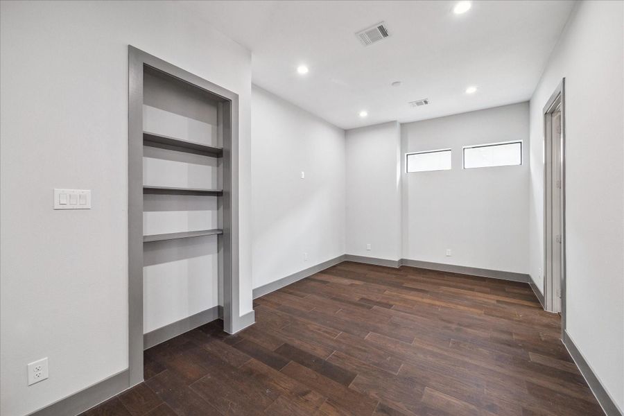 Designed for versatility, this bonus room includes built-in shelving and recessed lighting, making it a great option for a home office, playroom, or media space. The neutral palette and hardwood flooring allow for easy personalization to fit your needs.