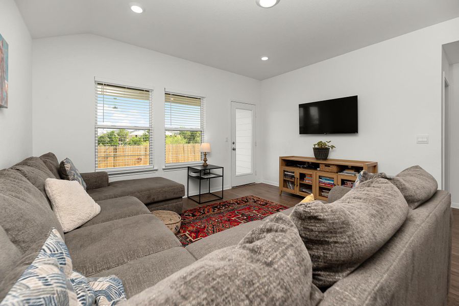 Living room featuring wood finished floors, recessed lighting, and vaulted ceiling