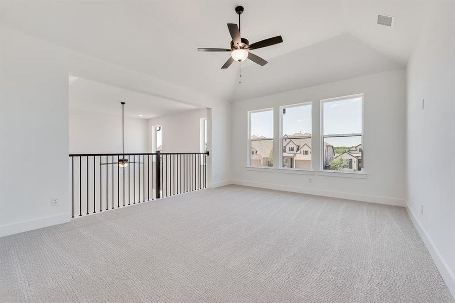 Carpeted empty room with a ceiling fan and healthy amount of natural light Carpeted empty room with a ceiling fan and healthy amount of natural light