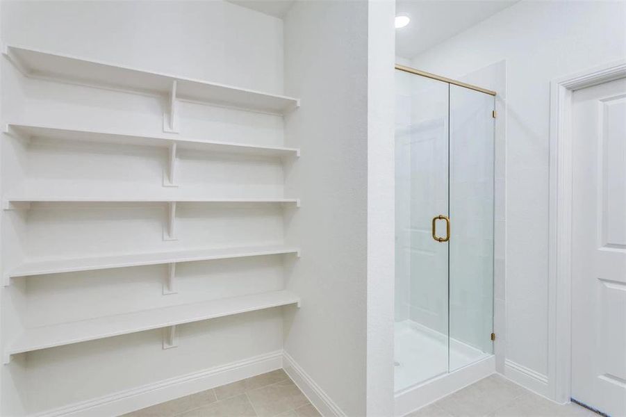 Bathroom featuring a shower stall and tile patterned flooring Bathroom featuring a shower stall and tile patterned flooring