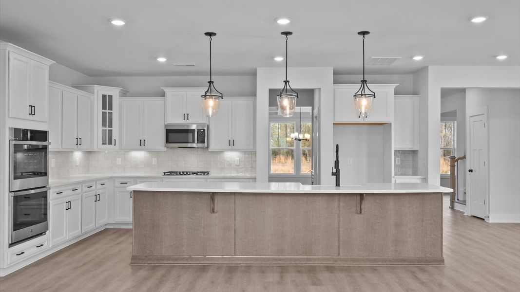 Elegant kitchen featuring a 9-foot island with pendant lighting and tasteful finishes throughout