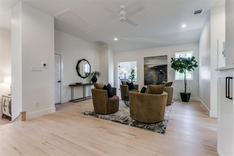 Living room with light wood-type flooring and ceiling fan