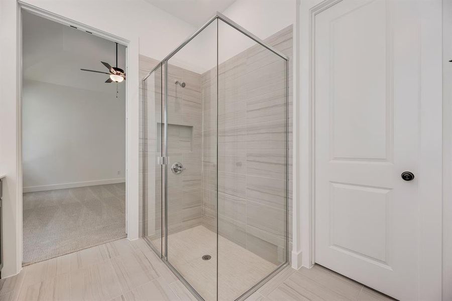 Full bath featuring a stall shower and a ceiling fan Full bath featuring a stall shower and a ceiling fan