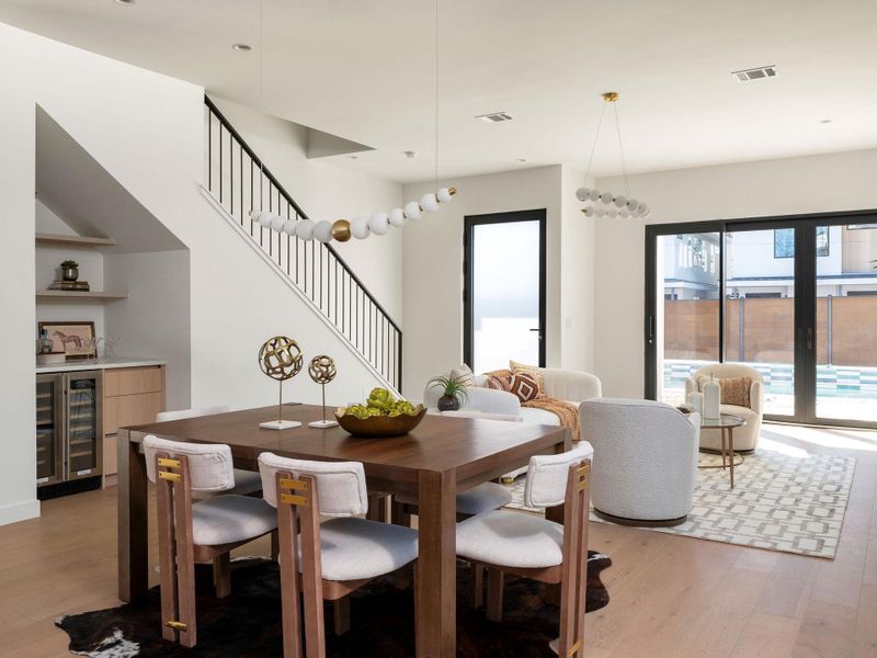 Dining area featuring light wood finished floors, beverage cooler, and a dry bar