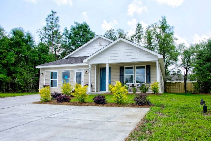 A house with a yard and trees with Little White House in the background.