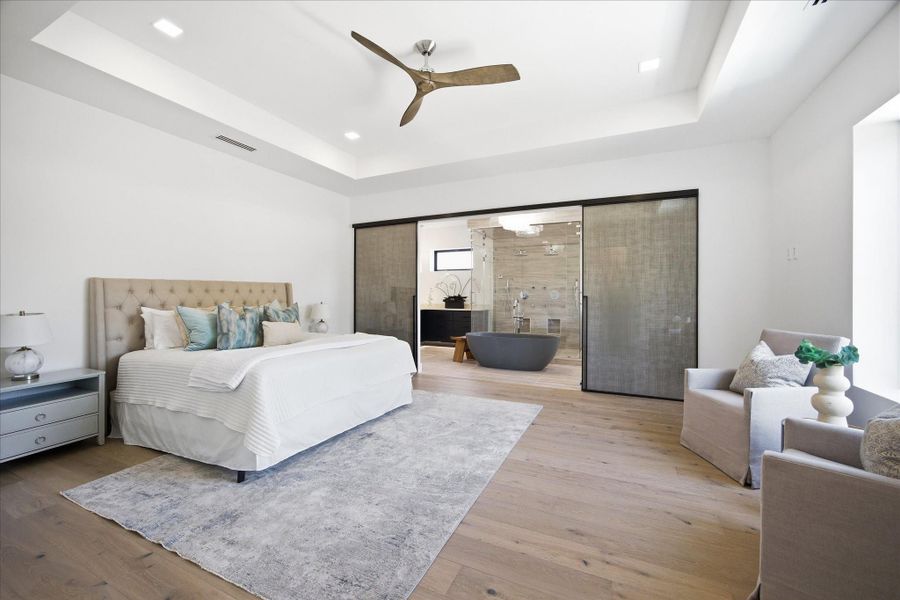 A true statement space, the upstairs primary suite offers expansive proportions, soaring tray ceilings, and a layout that immediately feels elevated and serene.