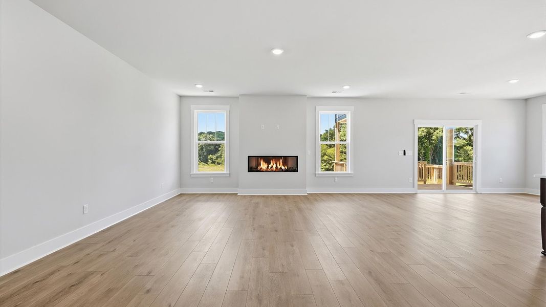 Elegant family room featuring hardwood flooring, large windows, and thoughtful architectural detail