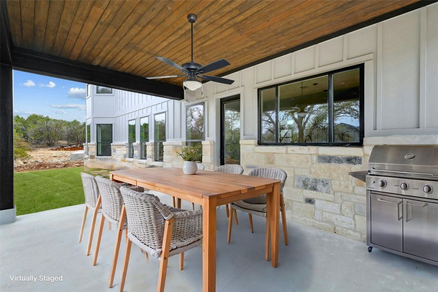 View of patio featuring ceiling fan, an outdoor kitchen, outdoor dining area, and grilling area