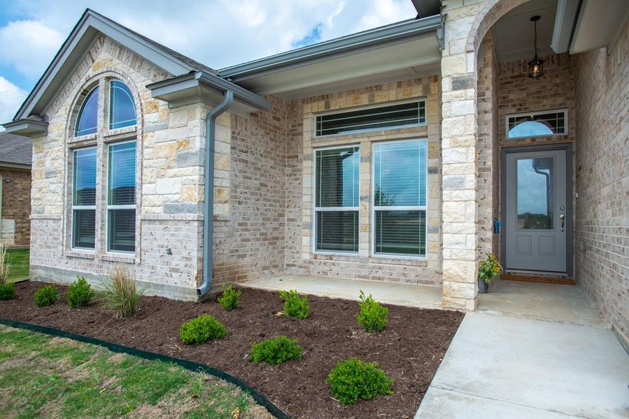 Doorway to property featuring stone siding and covered porch Doorway to property featuring stone siding and covered porch
