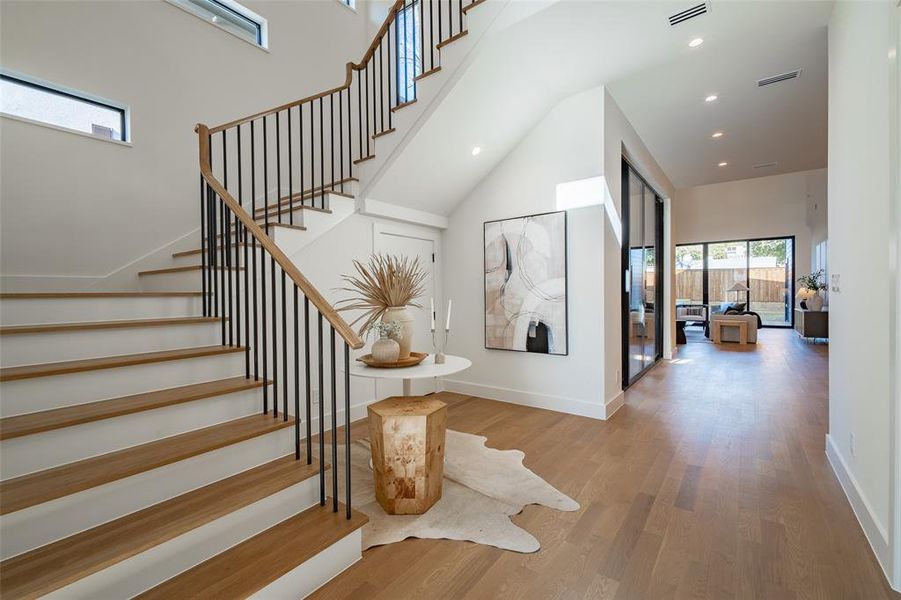 Stairway featuring hardwood / wood-style flooring and a towering ceiling