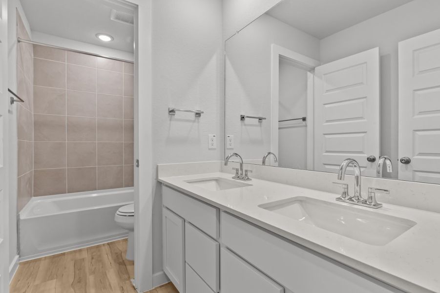 A bathroom with a tub sink and toilet. A bathroom with a tub sink and toilet.