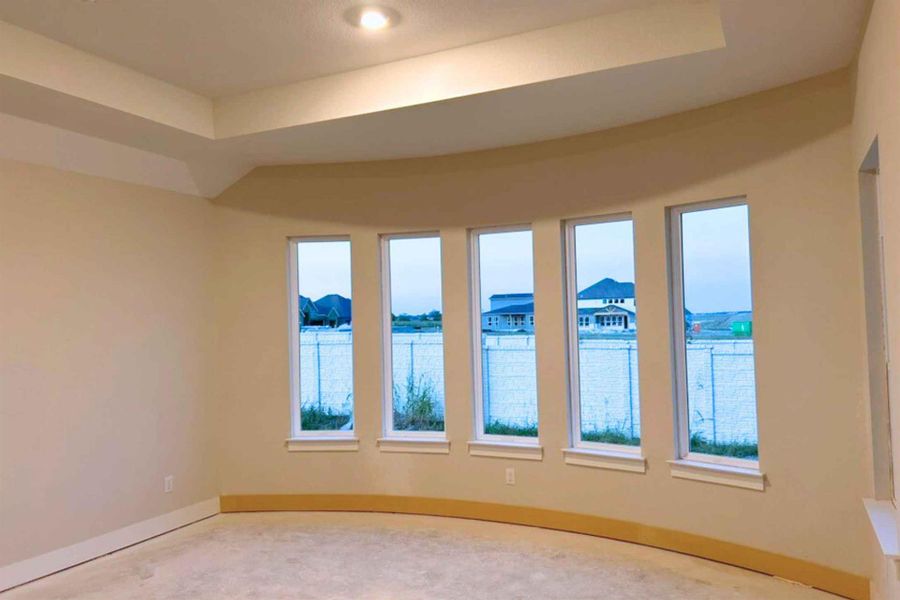 Spare room featuring a tray ceiling and baseboards