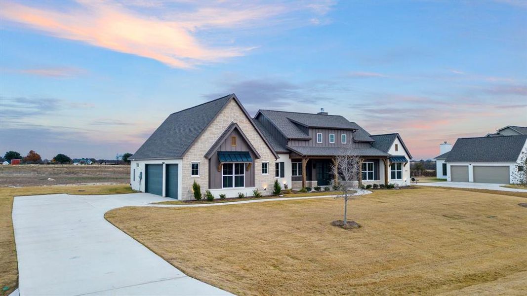 View of front facade with a garage and a yard