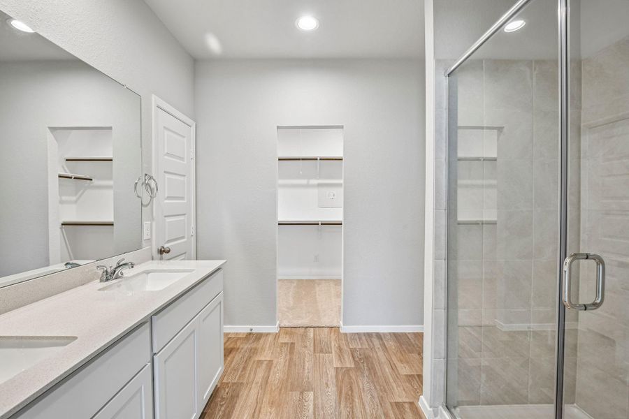 The primary bathroom features a spacious and well-designed layout, centered around both comfort and functionality.