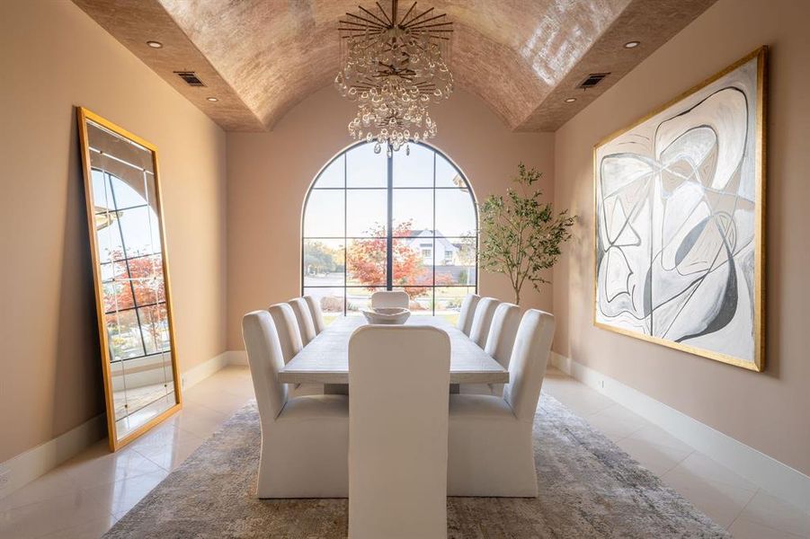 Dining room featuring plenty of natural light, vaulted ceiling, and a chandelier