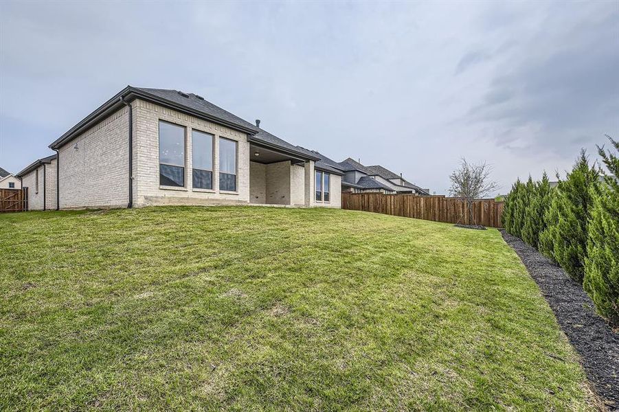 Back of house featuring brick siding, a fenced backyard, and a patio
