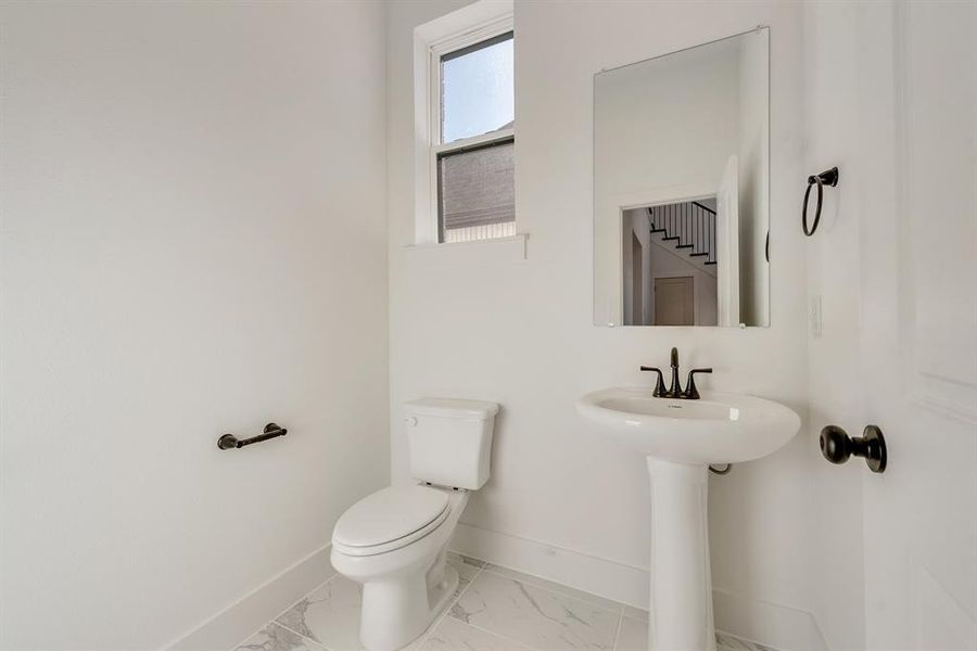 Bathroom featuring baseboards and marble finish floors Bathroom featuring baseboards and marble finish floors