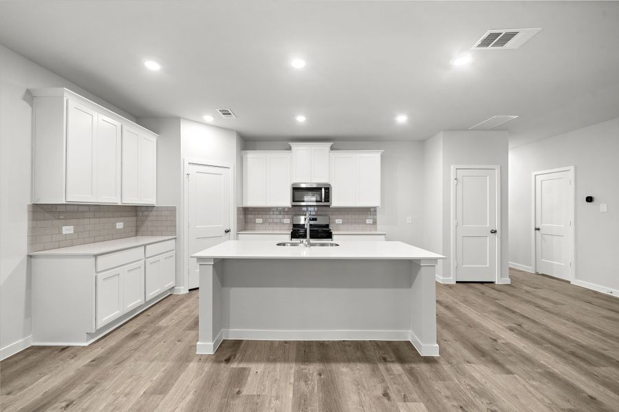 A kitchen with white cabinets.