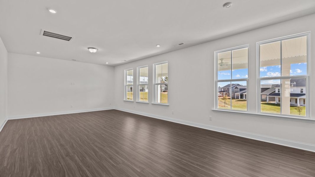 Burton Design open concept family room with large windows for abundant natural light. At Lakeside Glen by DRB Homes, York, SC