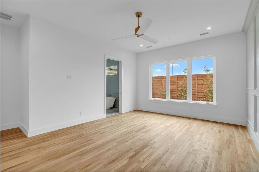 Unfurnished bedroom with light wood-style floors, a ceiling fan, recessed lighting, and ensuite bathroom