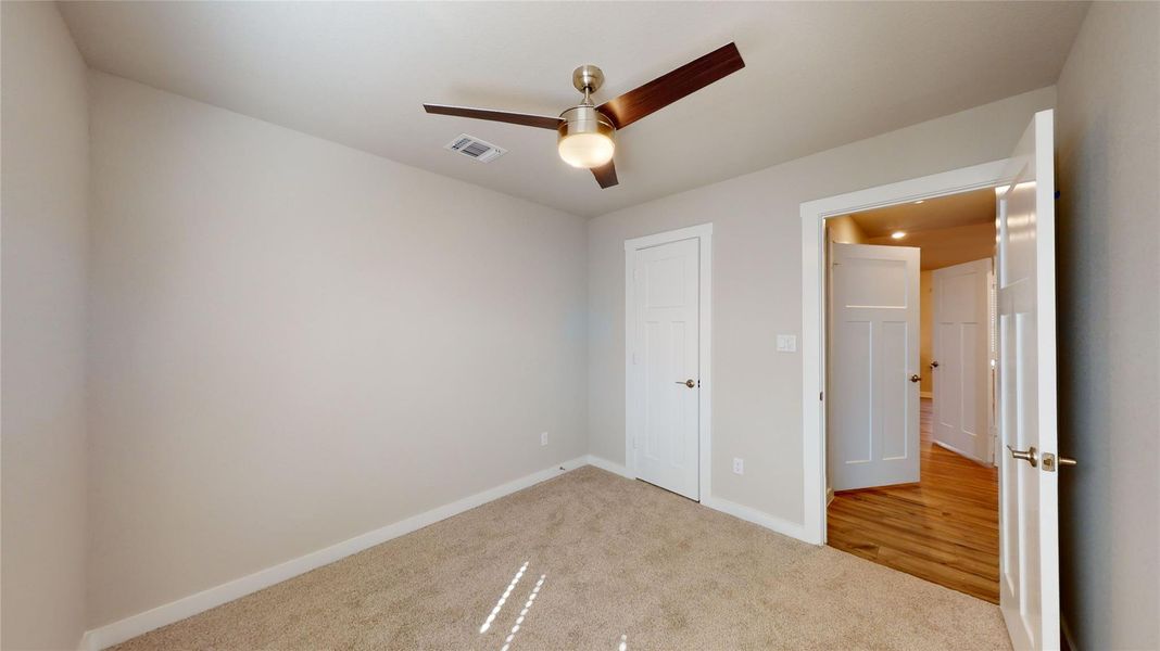 A well-lit room offers cozy carpeting and a contemporary ceiling fan for year-round comfort. A well-lit room offers cozy carpeting and a contemporary ceiling fan for year-round comfort.