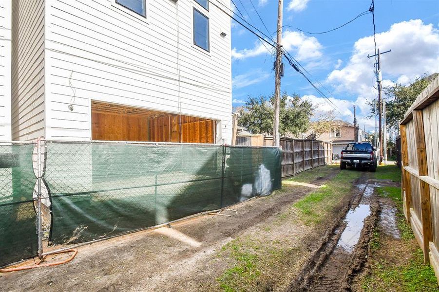 Alley under construction to be driveway to garage doors.