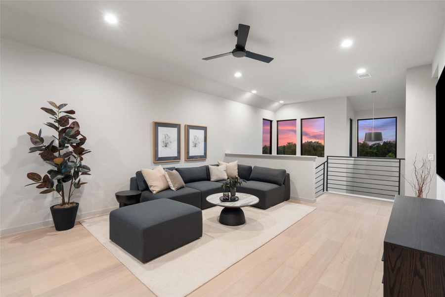 Hardwood flooring extends throughout this light-filled room, accented by a ceiling fan and recessed lighting. Hardwood flooring extends throughout this light-filled room, accented by a ceiling fan and recessed lighting.