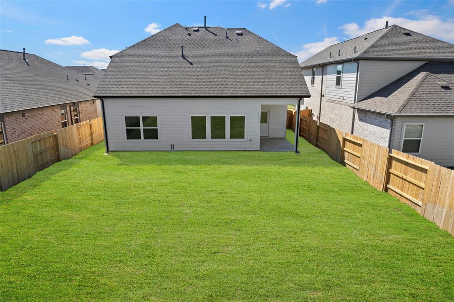 Generous backyard with covered patio — ideal for outdoor dining or relaxing in the shade.