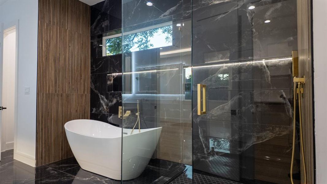 Full bathroom with a freestanding tub, marble tiled floors, and a marble finish shower