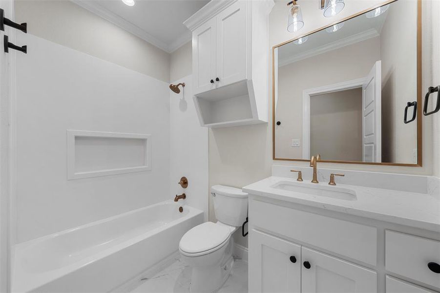 Full bathroom with ornamental molding, tub / shower combination, vanity, and light marble finish floors Full bathroom with ornamental molding, tub / shower combination, vanity, and light marble finish floors