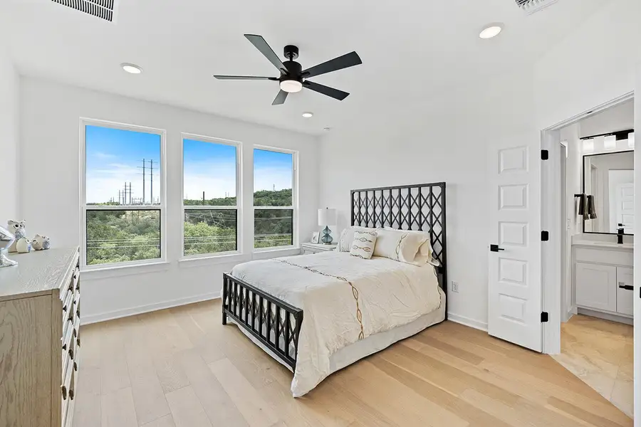 Primary Bedroom with views.  Light wood finished floors, and ensuite bathroom