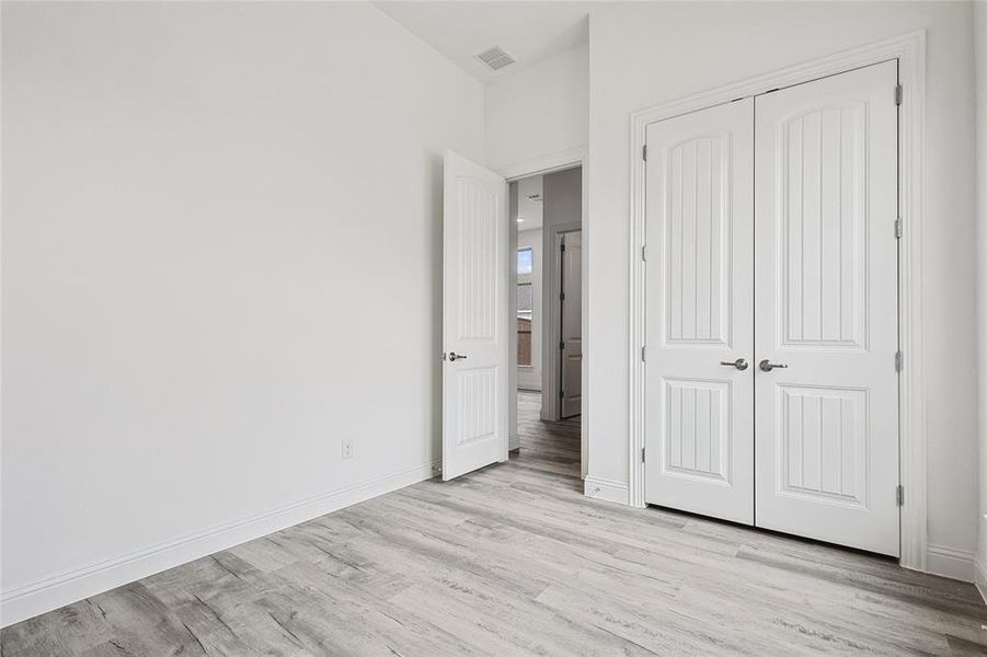 Unfurnished bedroom with light hardwood / wood-style flooring and a closet