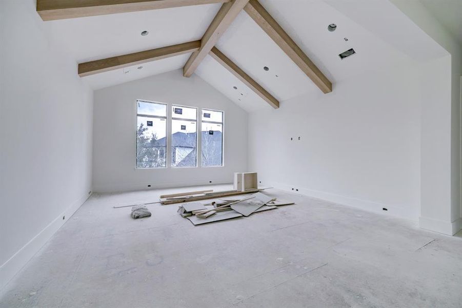 Second floor game room with stained beams, vaulted ceilings, wood floors and hanging fixture to come.