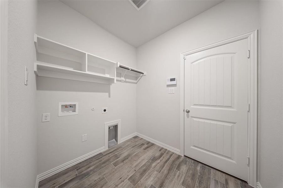 Laundry area with electric dryer hookup, gas dryer hookup, wood finished floors, and washer hookup