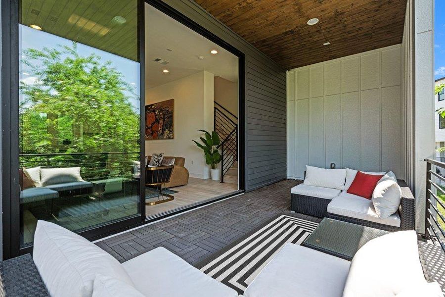Covered balcony with wood-paneled ceiling, modern tile flooring, and seamless indoor-outdoor living space.