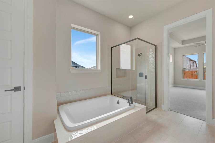 Bathroom with a stall shower, a garden tub, and plenty of natural light