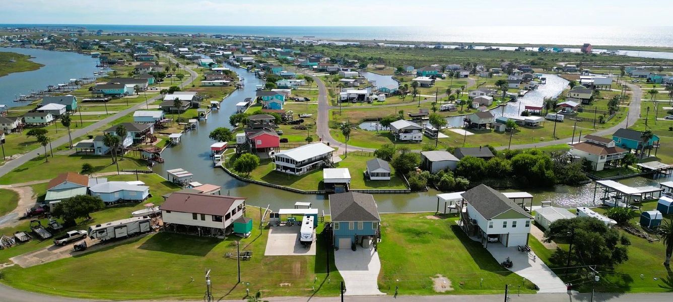 This photo showcases this coastal community with homes along canals, offering waterfront living. The area features a mix of modern and traditional houses and easy access to water activities. Ideal for those seeking a serene, picturesque environment near the Gulf and Bay.