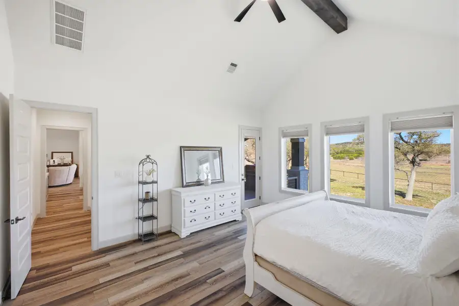 The property features an interior space with vaulted ceilings, exposed dark wood beams, and light wood flooring