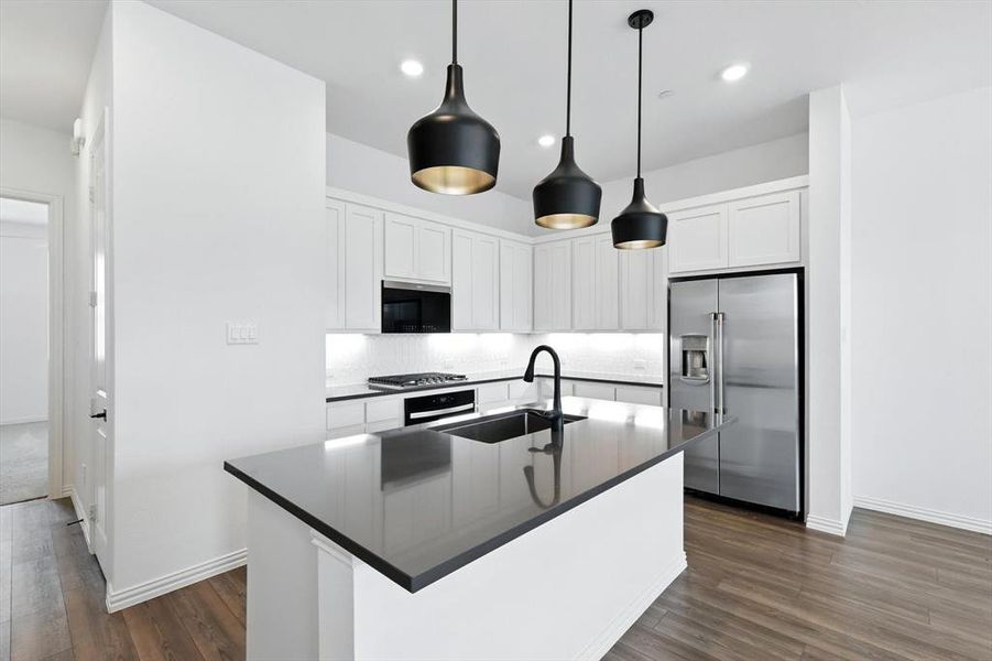 A GE cafe refrigerator that conveys. A gas cooktop and separate oven.