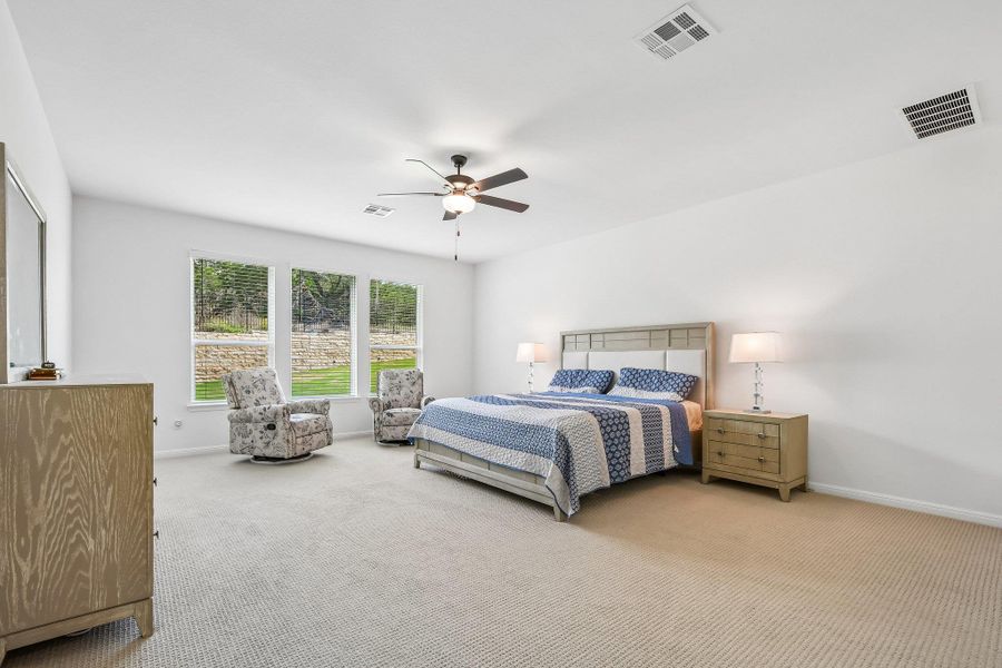 An airy primary bedroom suite features serene views and ample space for relaxation.