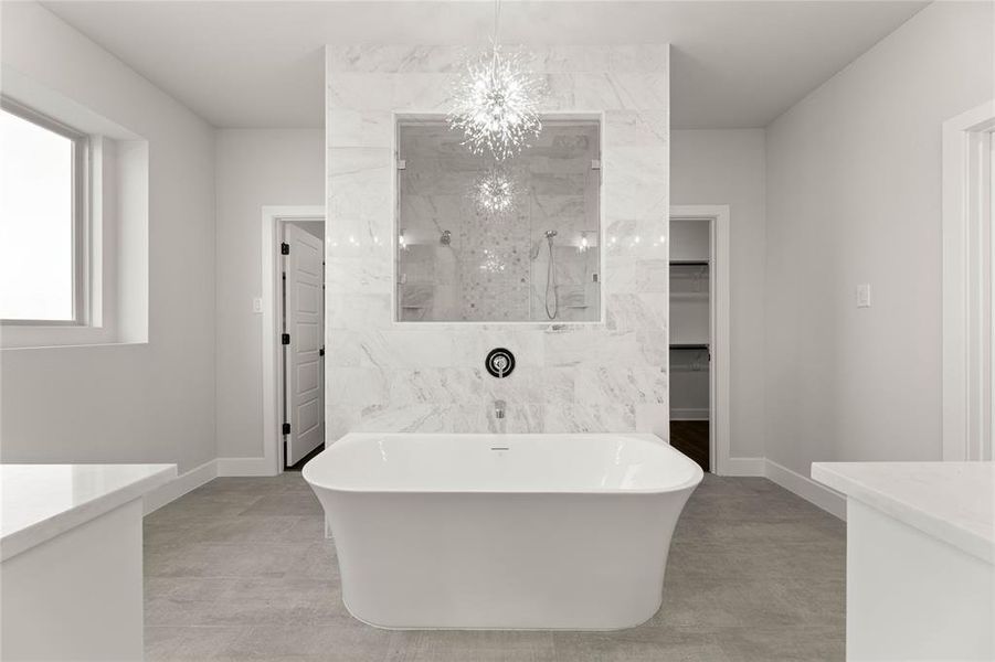 Full bath featuring vanity, a spacious closet, a freestanding tub, and a marble finish shower Full bath featuring vanity, a spacious closet, a freestanding tub, and a marble finish shower