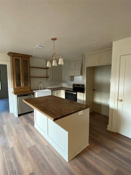 Kitchen with range, pendant lighting, light hardwood / wood-style floors, and dishwasher